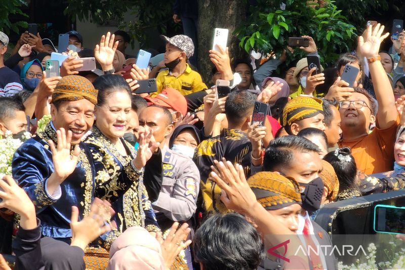 Presiden Joko Widodo bersama istri menyapa masyarakat mengikuti prosesi kirab pengantin Kaesang Pangarep dan Erina Gudono di depan Loji Gandrung Solo, Minggu
