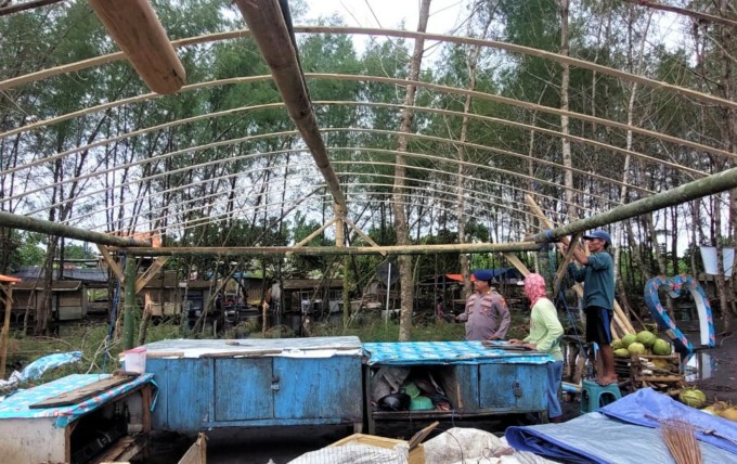 DIPERBAIKI LAGI: Pemilik warung di Pantai Cemara, Dusun Getem, Desa Mojomulyo, Kecamatan Puger, Jember, memperbaiki lapak mereka setelah rusak akibat angin kencang dan banjir rob.