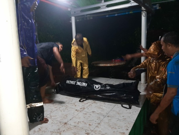 PENYISIRAN: Petugas menyiapkan kantong jenazah selama pencarian jasad korban yang makamnya bongkar akibat banjir, di sekitar sungai Kali Jompo, Rabu (28/12) malam.