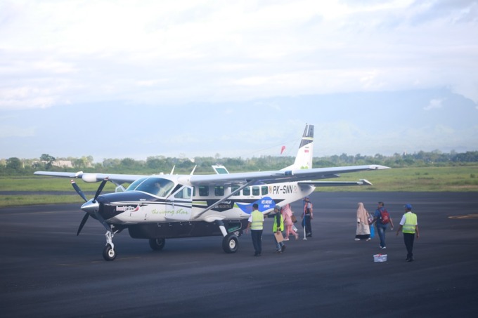 AKAN MENGUDARA: Para penumpang bersiap menaiki pesawat Cessna Grand Caravan dengan rute penerbangan menuju Surabaya, di Bandara Notohadinegoro, kemarin (5/1).