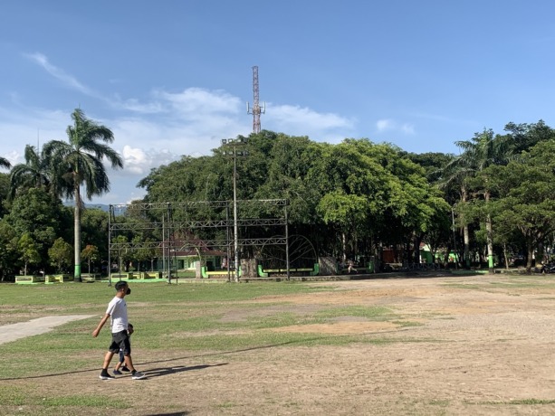 PUSAT KOTA: Masyarakat saat melintas di lapangan Alun-Alun Bondowoso yang telah menguning karena rusak saat ditempati bazar pada pengujung tahun 2022 lalu. 
