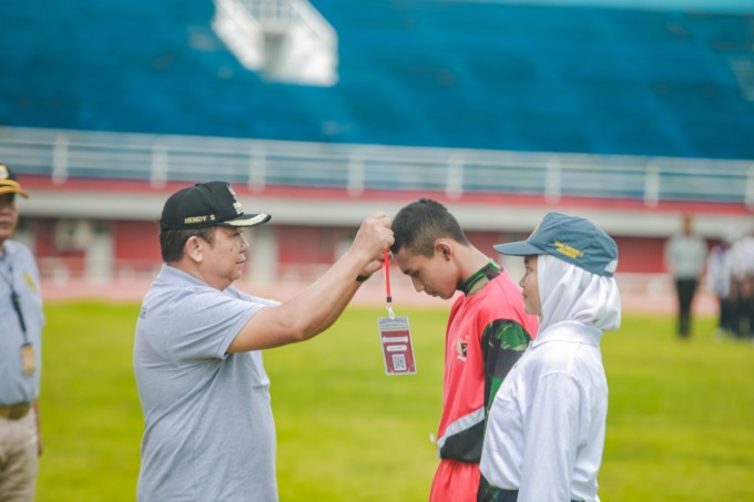 PENYEMATAN: Bupati Jember Hendy Siswanto saat pengalungan tanda peserta latihan gabungan paskibra Jember, Sabtu (28/1), di Stadion JSG.