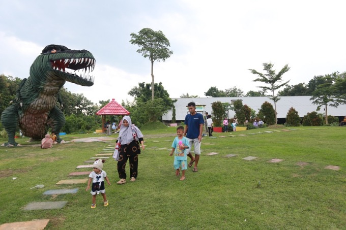 NIKMATI LIBURAN: Masyarakat sekitar menikmati taman TPA Pakusari. Meski terkadang berbau tak sedap, namun tak jadi penghalang untuk menikmati fasilitas maupun spot foto yang ada.