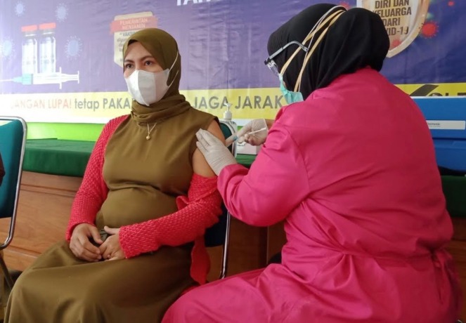 SERIUS: Salah seorang warga ketika mendapatkan vaksinasi dari tim vaksinator.