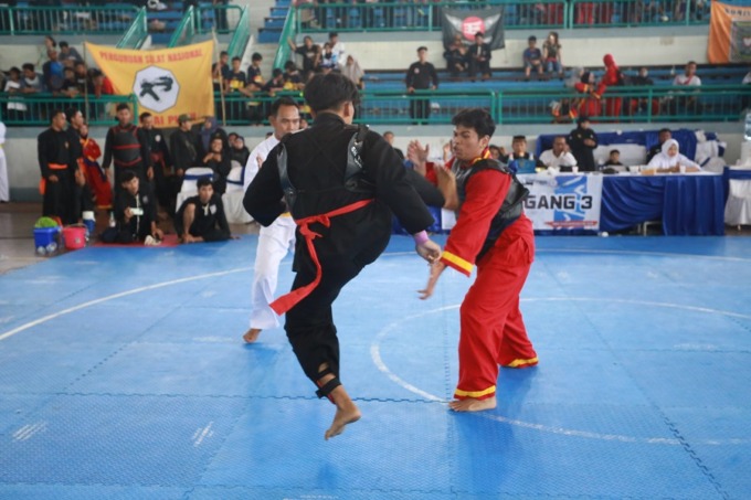 BERTANDING: Dua pesilat dari luar daerah adu teknik untuk memperebutkan tiket final pada event Piala Kemenpora di GOR PKPSO Kaliwates.