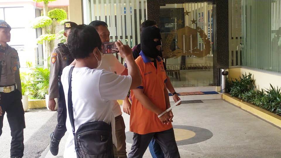 DITAHAN: Muhammad Fahim Mawardi, pengasuh Ponpes Al Djaliel 2, Desa Mangaran, Kecamatan Ajung, digiring menuju sel Polres Jember setelah kasusnya dirilis, kemarin.