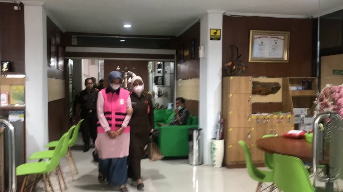 MULAI DILUCUTI: Tersangka kasus penjualan obat di luar SOP rumah sakit saat keluar dari Kejari Jember. Kini, dia telah diputus kontrak, serta tanah dan bangunannya dilakukan penyitaan.