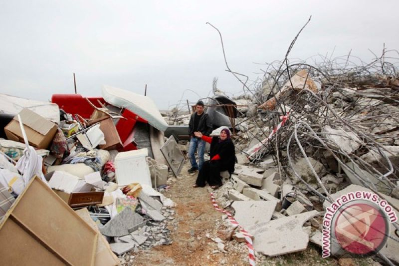 Seorang perempuan Palestina duduk di tengah reruntuhan rumahnya yang dihancurkan di pemukiman Beit Hanina, Yerusalem Timur, Selasa (5/2). Kotamadya Yerusalem mengatakan bahwa ada perintah pengadilan untuk membongkar rumah tersebut, yang dibangun tanpa izi