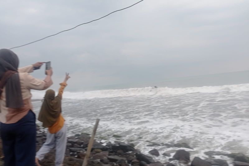 Wisatawan di pesisir Pantai Anyer menghadap arah Gunung Anak Krakatau di Perairan Selat Sunda yang tertutup kabut.