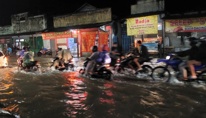 TERENDAM: Para pengendara nekat menerobos genangan air di Jalan Raya Kecamatan Jenggawah, Jember, kemarin malam.