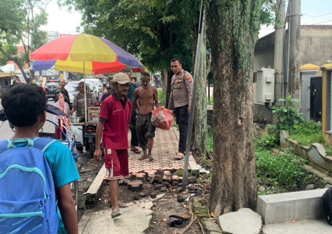DIAMANKAN: Aparat kepolisian ketika mengamankan ODGJ yang sempat mengamuk di depan SDN Dabasah 5 Bondowoso.