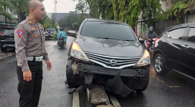 KECELAKAAN TUNGGAL: Mobil Grand Livina P 1833 QL yang nangkring di atas pembatas jalan samping GNI, Kelurahan Kepatihan, Kecamatan Kaliwates, Jember, Senin (16/1).
