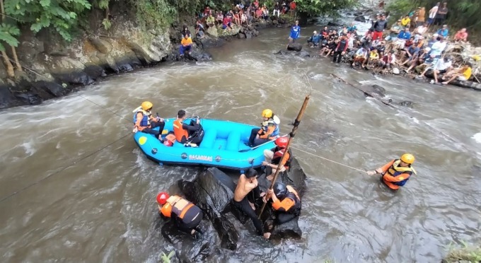 TERUS MENCARI: Tim Basarnas menggunakan perahu karet dan alat selam dalam proses pencarian korban hanyut di sungai Desa Darungan, Kecamatan Ledokombo, Jember, Jumat (20/1).