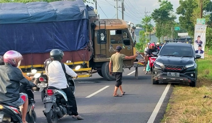 ADANG JALAN: Truk Fuso terperosok di Jalan M Yamin Tegalbesar, Kaliwates, Jember, Selasa (31/1) pagi. Peristiwa ini menyebabkan jalanan macet.