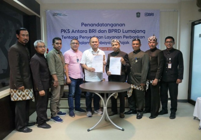 SINERGI: Pemimpin KC BRI Lumajang Hendra Affandi Rambe (baju putih) berfoto bersama Plt BPRD Lumajang Endhi Setyo Arifianto, seusai penandatangan PKS pelayanan perbankan pembayaran pajak, Rabu (15/2). (Muhammad Sidkin Ali/Rame)