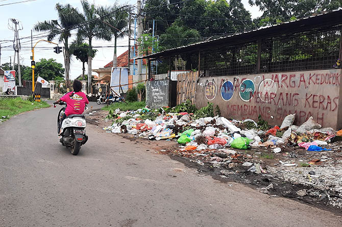 Tampak Pengendara motor melintas di depan TPS Kedopok sudah lama ditutup, tapi di TPS itu masih saja terlihat onggokan sampah terutama sampah rumah tangga