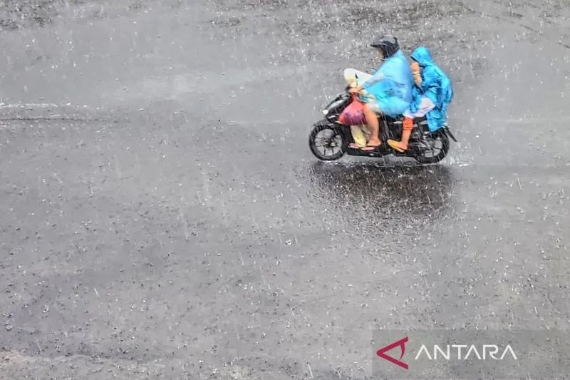 Arsip foto - Pengguna jalan melintas ketika hujan deras mengguyur kawasan Kota Surabaya, Jawa Timur, Rabu (25/1/2023).