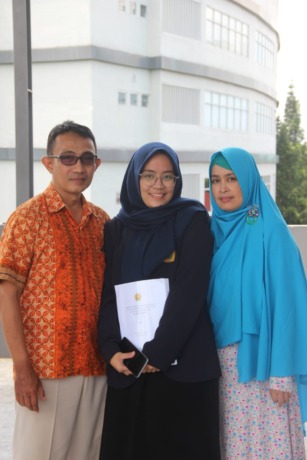 BAHAGIA: Chinta merayakan selesainya sidang skripsi dan berfoto bersama kedua orang tuanya.
