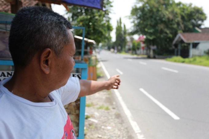 TUNJUK LOKASI: Sihebudi, warga Kelurahan/Kecamatan Patrang, menunjukkan lokasi yang menjadi langganan kecelakaan di Jalan PB Sudirman.