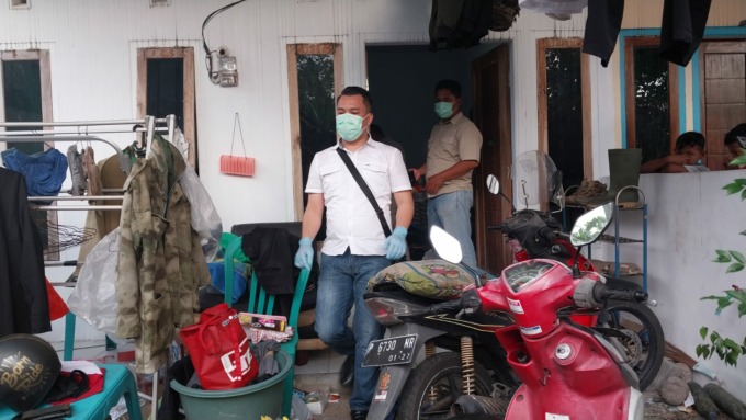 TOLAK OTOPSI: Tim Inafis Polres Jember melakukan olah TKP di rumah kontrakan korban Desa Tanggul Kulon, Kecamatan Tanggul, Jember, Selasa (21/2). Keluarga menolak jenazah korban diotopsi. (Foto: Jumai/Radar Jember)