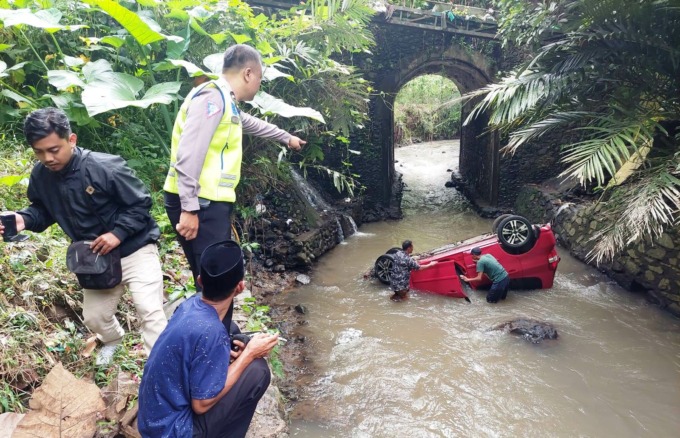 RINGSEK: Kondisi mobil yang masuk ke sungai sedalam 15 meter di Jember, Kamis (16/2). Kendaraan itu berisi empat orang, dua di antaranya masih balita. (Foto: Satlantas untuk Radar Jember)