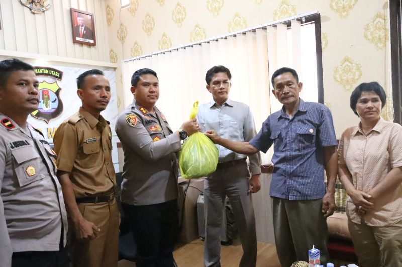 Kapolres Malinau AKBP Andreas Deddy Wijaya saat menerima barang bukti berupa baju milik LH yang korban penembakan anggota polisi Brigpol W di Mapolres Malinau pada, Senin malam (6/2).
