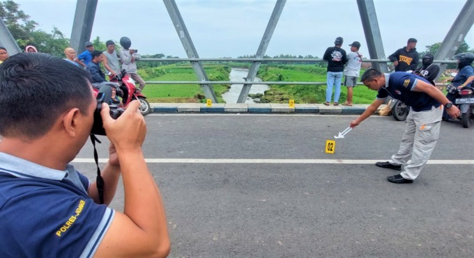 KUMPULKAN BUKTI: Tim Inafis Polres Jember melakukan olah TKP di Jembatan Pocong, lokasi dua pemuda terjatuh dan hanyut di Kali Tanggul, Dusun Ponjen, Desa/Kecamatan Kencong, Jumat (3/2).