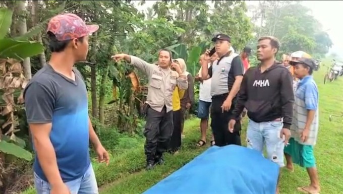 SUDAH KETEMU: Keluarga korban bersama polisi mengevakuasi jenazah korban ke puskesmas setempat. Setelah pemeriksaan medis, dua jenazah ini akan diserahkan ke keluarga masing-masing.