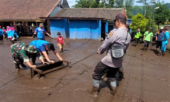 GOTONG ROYONG: Berbagai unsur terlibat membersihkan sisa banjir bandang di SDN Sempol 1, Kecamatan Ijen, Bondowoso, Selasa (14/2).