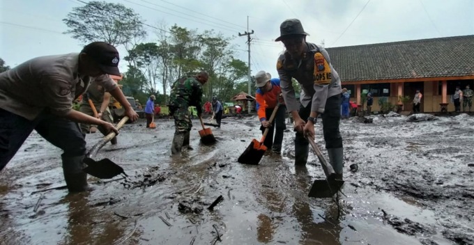 BERSIHKAN LUMPUR: Personel gabungan TNI dan Polri terus membersihkan sejumlah titik yang terdampak banjir bandang di SDN Sempol 1, Kecamatan Ijen, Bondowoso, Rabu (15/2). (Jumai/Radar Jember)
