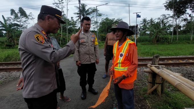 RELAWAN: Enjan, 67, warga setempat, setiap hari menjaga perlintasan tanpa palang pintu di Dusun Krajan Kidul, Desa Yosorati, Kecamatan Sumberbaru.