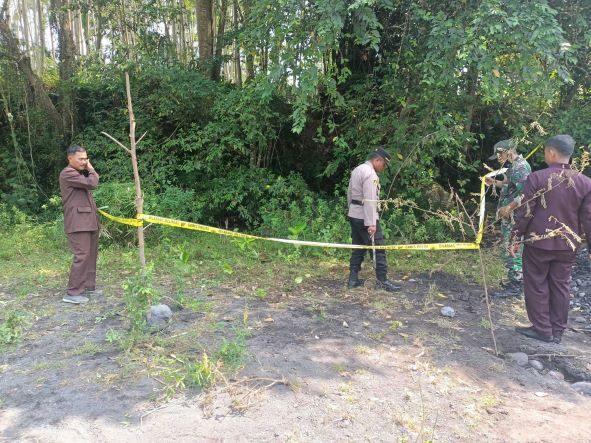 DIBATASI: Muskpika Pasirian bersama perangkat Desa Bades, Kecamatan Pasirian, memasang garis polisi di lokasi tanah goyang. Ini untuk menghindari hal-hal yang membahayakan.