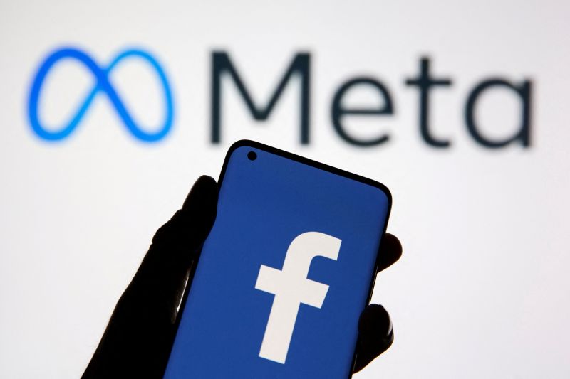 Arsip foto - Sebuah ponsel menampilkan logo Facebook di depan logo baru perusahaan induk Meta Platforms Inc (28/10/2021).
