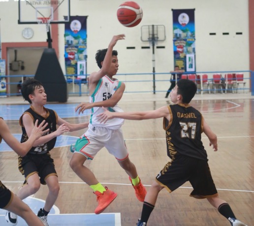KECOH LAWAN: Pemain SMPN 2 Jember (jersey putih) terus menekan pertahanan lawannya, SMPK Maria Fatima, dalam laga JBL Reborn, kemarin (5/3), di GOR Garuda Kaliwates.