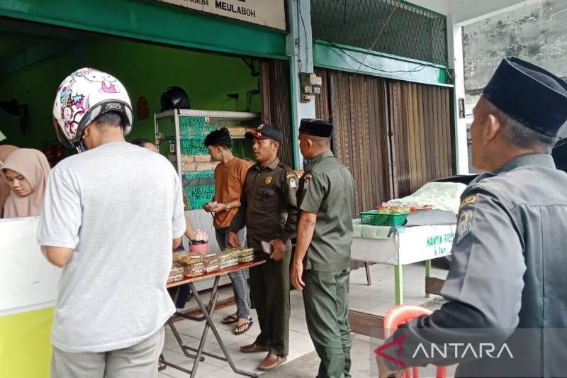 Petugas Wilayatul Hisbah (WH) menegur pedagang yang menjual makanan di siang hari saat bulan suci Ramadhan 1444 Hijriyah, di ruas Jalan Merdeka, Meulaboh, karena melanggar ketentuan syariat Islam dan meminta toko tersebut ditutup, Sabtu (25/3/2023).