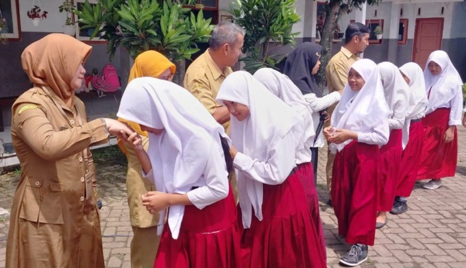 KHIDMAT: Siswa SDN Badean 01, Kecamatan Bangsalsari, Jember, menyalami para guru sesuai mengikuti lomba menghias tumpeng menyambut Ramadan 1444 H. (Foto: Jumai/Radar Jember)