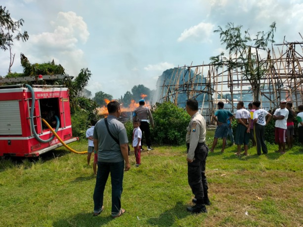 LUDES: Petugas pemadam kebakaran saat berusaha memadamkan api yang membakar gudang pengeringan tembakau milik PTPN X Kertosari di Kecamatan Pakusari, Jember, Selasa (21/3). (Foto: Polsek Pakusari untuk Radar Jember)