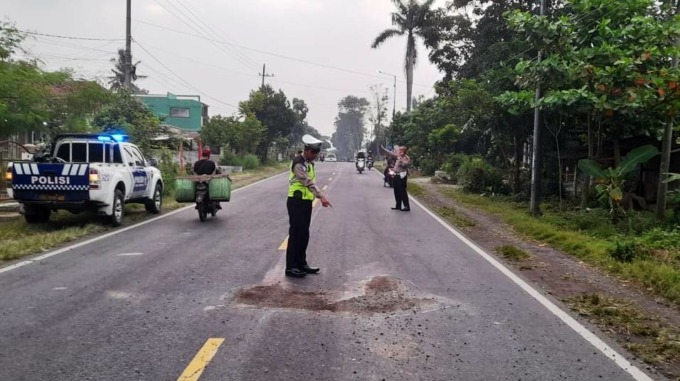 KUMPULKAN BUKTI: Petugas Unit Laka Lantas Satlantas Polres Jember melakukan olah TKP di lokasi kecelakaan. Tepatnya, di jalan raya sebelah barat Kantor Desa Gambirono, Kecamatan Bangsalsari, Jember, Selasa (28/3) siang.