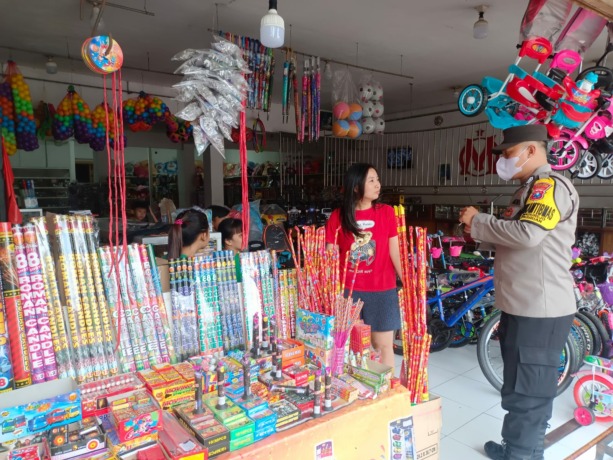 MASIH DIJUAL: Personel Polsek Pasirian memberikan imbauan kepada salah satu penjual petasan di Pasar Desa/Kecamatan Pasirian. Hal ini untuk menekan peredaran penjualan petasan di masyarakat.