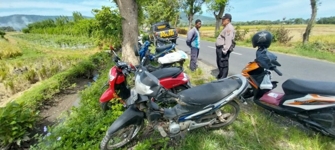 BERI IMBAUAN: Anggota Polsek Wuluhan mengimbau kepada pemilik sepeda motor agar tidak lengah saat parkir di pinggir jalan.