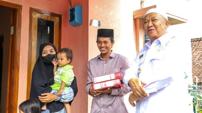 PENUHI GIZI BALITA: Bupati Jember Hendy Siswanto saat memberikan PMT kepada ibu dan balita.