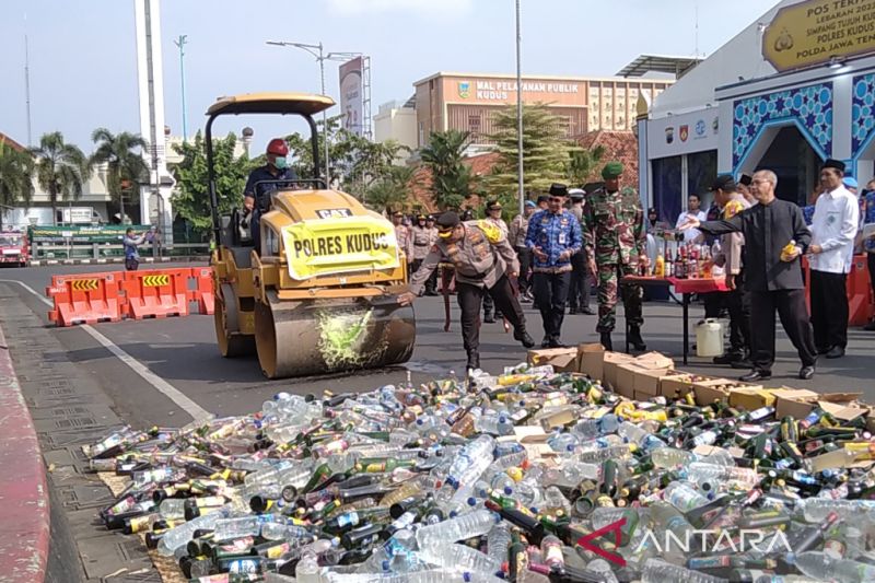 Kapolres Kudus AKBP Dydit Dwi Susanto memecahkan botol minuman keras ke kereta penghalus jalan di Alun-alun Kudus, Jawa Tengah, Senin (17/4/2023).