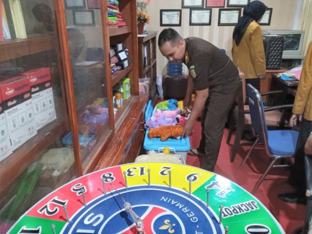 TEMUAN POLISI: Jaksa dari Kejaksaan Negeri (Kejari) Jember ketika menerima barang bukti perjudian yang diserahkan oleh pihak kepolisian dari Polsek Jenggawah.