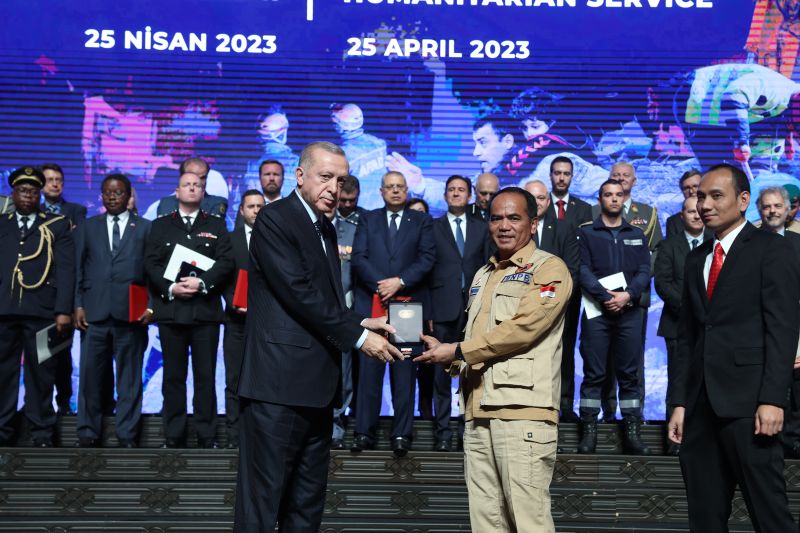Presiden Turki Recep Tayyip Erdogan (kiri) menyerahkan medali penghargaan kepada pemerintah RI yang diwakili oleh Staf Khusus BNPB Brigjen Lukmansyah (kanan) atas misi penyelamatan Indonesia pasca gempa Turki.