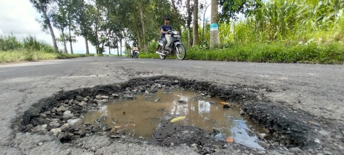 AWAS TERJEBAK: Kubangan jalan rusak cukup dalam di jalan raya Dusun Gambiran, Desa/Kecamatan Mumbulsari.
