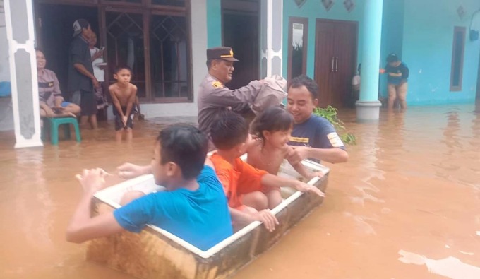 SELAMATKAN PENDUDUK: Anggota kepolisian dan warga mengevakuasi anak-anak yang rumahnya terendam banjir. Tak ada korban jiwa dalam bencana yang terjadi di Dusun Tunggangan, Desa Yosorati, Kecamatan Sumberbaru, Jember, Kamis (13/4).