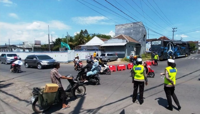 REKAYASA LALIN: Anggota Satlantas Polres Jember saat melakukan pengaturan lalu lintas di simpang tiga Wirolegi, Kecamatan Sumbersari. (FOTO: Jumai/Radar Jember)