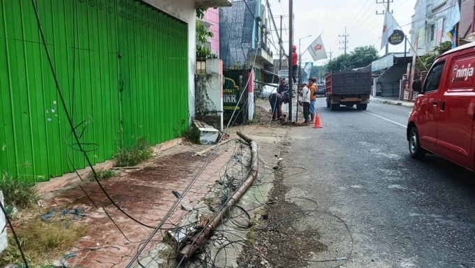 RUSAK: Petugas memperbaiki sejumlah tiang yang sempat roboh akibat ditabrak truk, Rabu (31/5) pagi. (Hasby/Radar Jember)