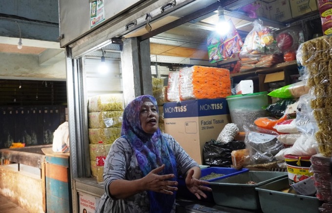 PASRAH: Khuriyah Indahwati menunggu pembeli di ruko Pasar Tanjung sembari menyiapkan bumbu untuk dijual di lapak sewaannya, Jumat (19/5).
