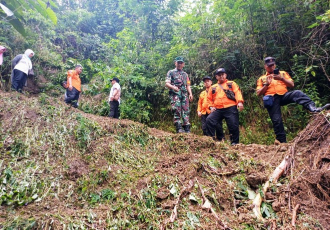 NAHAS: Petugas meninjau lokasi longsor di Desa Lanas, Kecamatan Botolinggo, Bondowoso, yang menimbulkan korban jiwa. (BPBD untuk Radar Ijen)